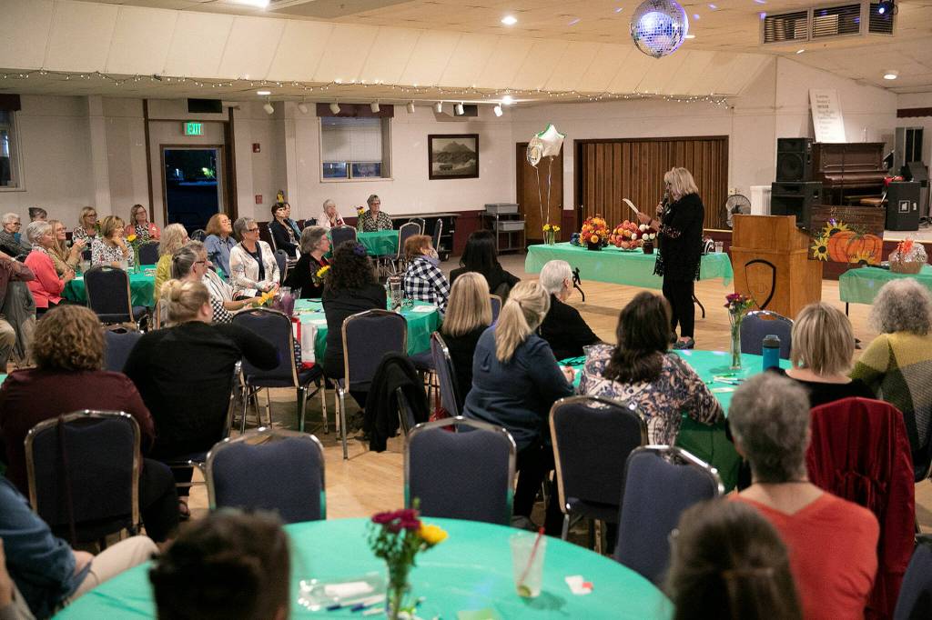 Janet Bacon speaks to a large crowd during 100+ Women Who Care About Snohomish Countys Giving Circle meeting at the Sons of Norway Normanna Lodge in Everett. (Ryan Berry / The Herald)
