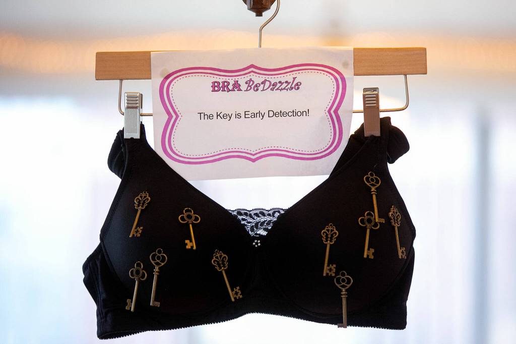 One of numerous punny and informational bras hangs from the ceiling at Citrine Health on Nov. 9, in Everett. (Ryan Berry / The Herald)