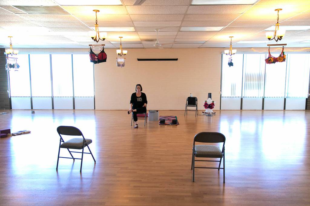 Emma Gardner, certified post mastectomy fitter and yoga instructor does a basic sitting yoga pose that she would do with her classes on Nov. 9, at Citrine Health in Everett. (Ryan Berry / The Herald)