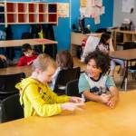 Riley, 7, left, and Under, 6, wait for breakfast at Tomorrows Hope Child Development Center in Everett. (Olivia Vanni / The Herald)