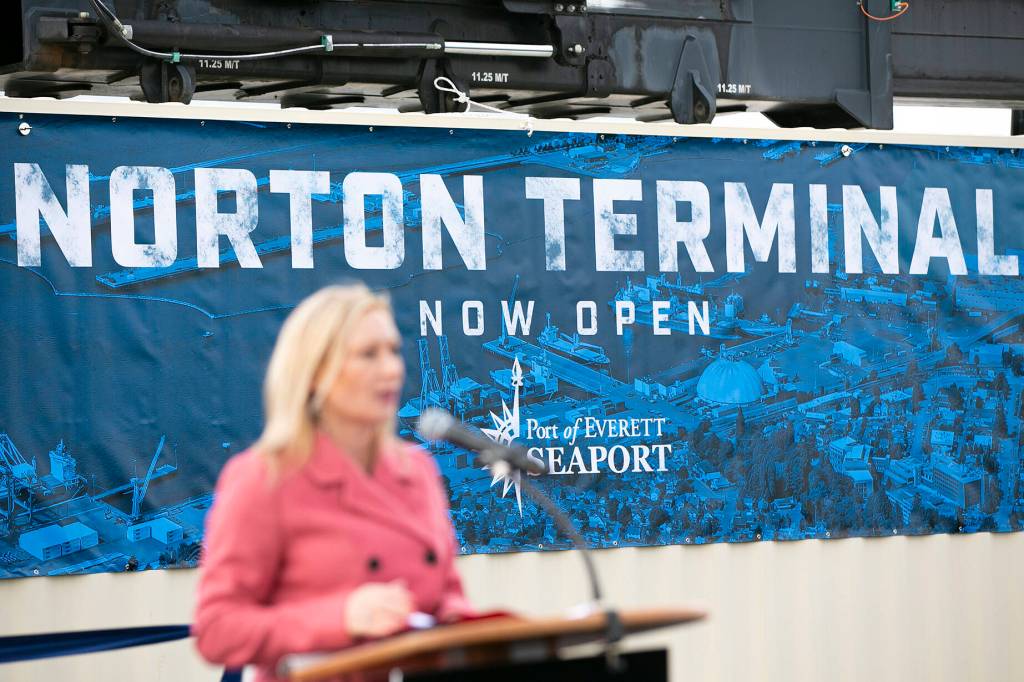 Lisa Lefeber, CEO of the Port of Everett, speaks to a crowd while in front of a sign celebrating the opening of the new Norton Terminal on Thursday, Dec. 1, 2022, at the Port of Everett in Everett, Washington. (Ryan Berry / The Herald)
