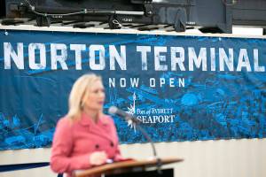 Lisa Lefeber, CEO of the Port of Everett, speaks to a crowd while in front of a sign celebrating the opening of the new Norton Terminal on Thursday, Dec. 1, 2022, at the Port of Everett in Everett, Washington. (Ryan Berry / The Herald)