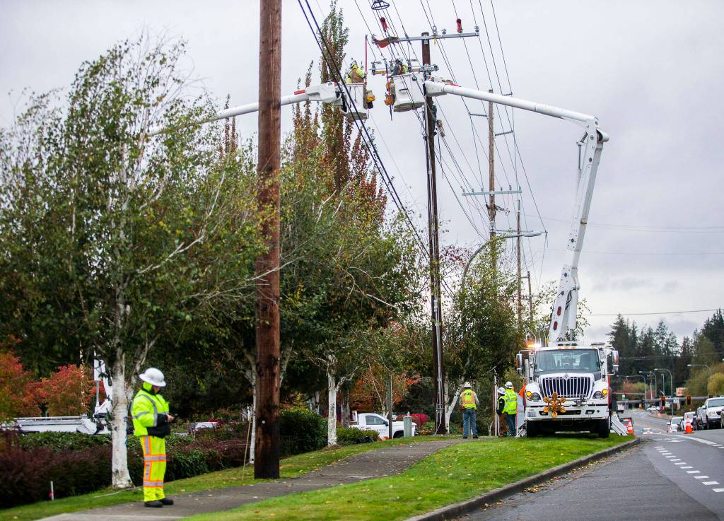 Traffic moves around Snohomish County PUD workers installing new transformers Oct. 25 along 132nd Street in Mill Creek. (Olivia Vanni / The Herald)