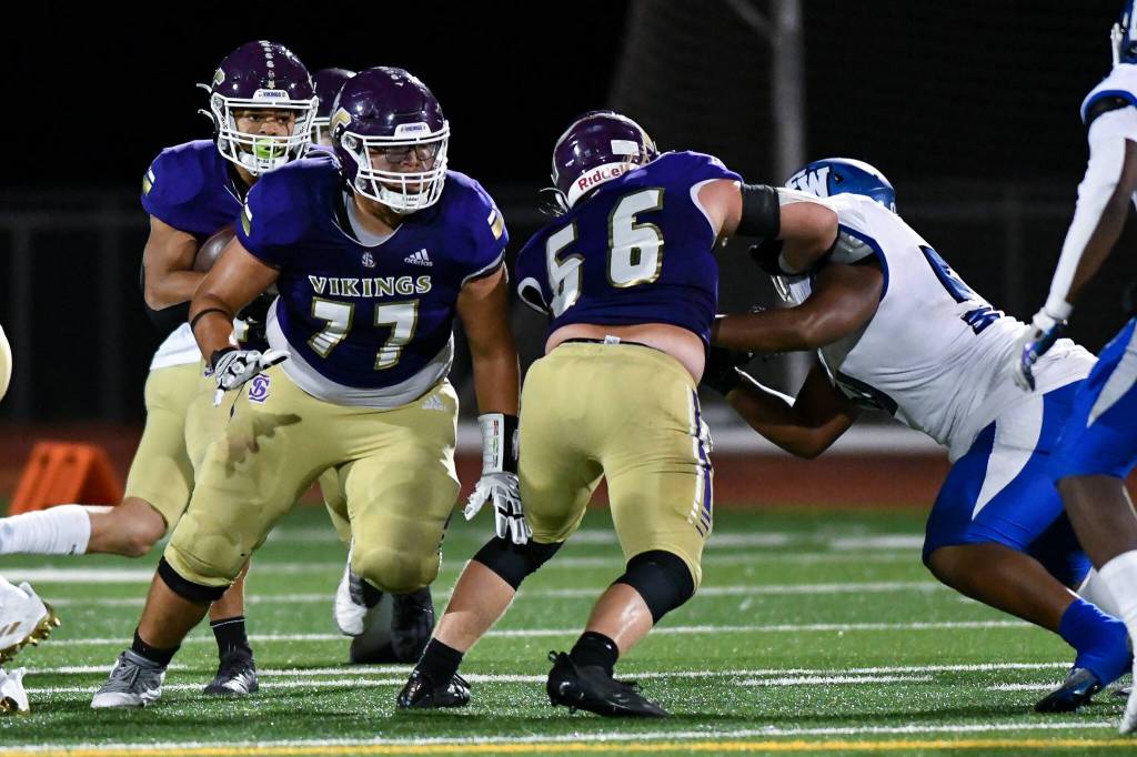 Lake Stevens Jayden Limar (rear) looks downfield behind the blocking of teammates Aaron Parker (77) and Ashten Hendrickson (66) during a game against Federal Way on Friday, Sept. 16, 2022, at Lake Stevens High School. (John Gardner / Pro Action Image)