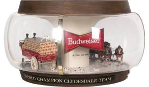 This advertising lamp includes figures of a team of horses pulling a beer cart with drivers, followed by a crowd of Dalmatians. Similar scenes may take place in real life on Budweiser’s promotional tours. The lamp with a moving wagon sold for $625.