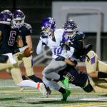 Lake Stevens defensive backs Paul Varela and Steven Lee Jr. force a fumble against North Creek. (Ryan Berry / The Herald)