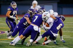 A gang of Lake Stevens Vikings take down the ball carrier during the 4A semifinal against Graham-Kapowsin on Saturday, Nov. 26, 2022, at Lake Stevens High School in Lake Stevens, Washington. (Ryan Berry / The Herald)