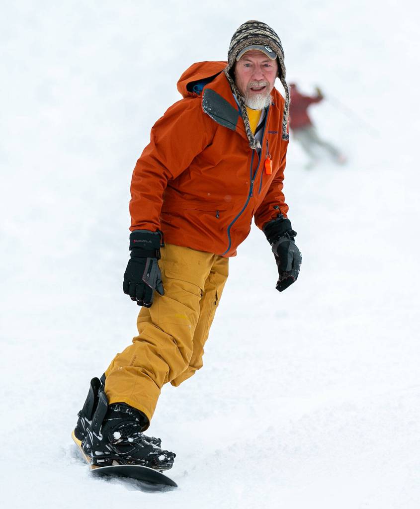 A man reaches the end of his run while snowboarding. (Ryan Berry / The Herald)