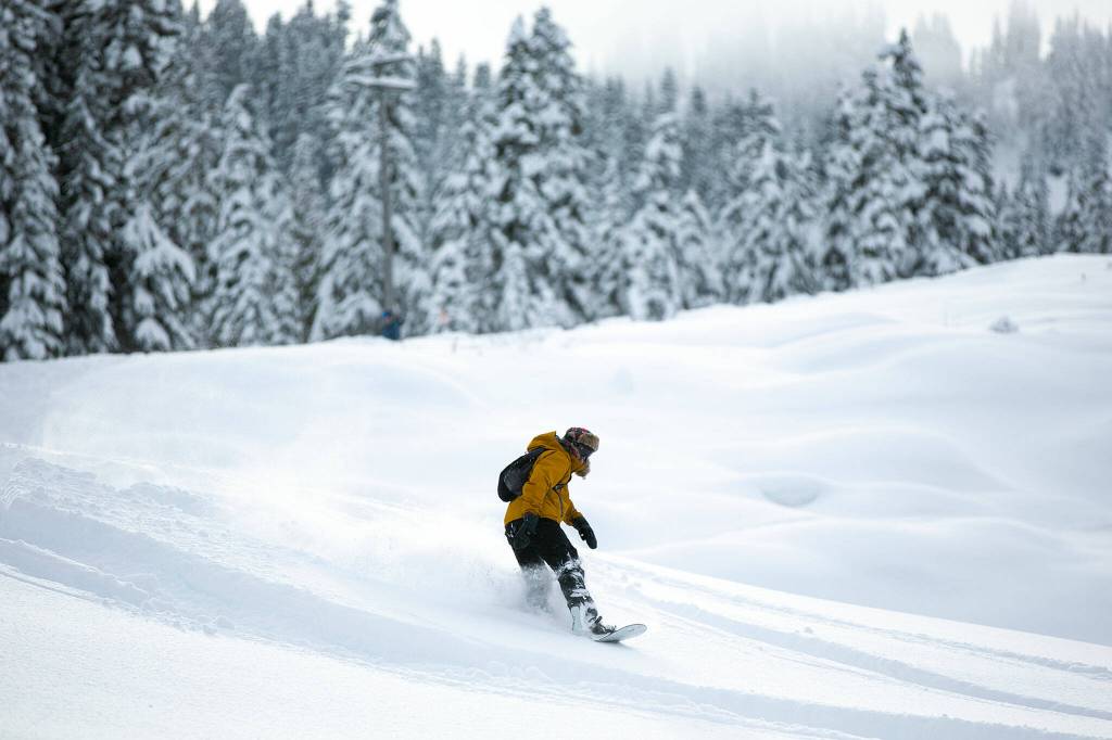 A snowboarder takes a detour through ungroomed snow. (Ryan Berry / The Herald)