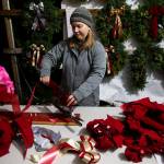 Mollie Rodriguez works on assembling bows for wreaths at the workshop on Dec. 5, in Monroe. (Olivia Vanni / The Herald)