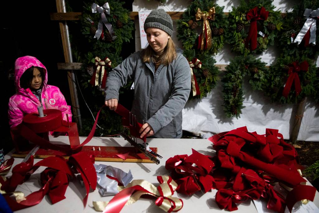 Mollie Rodriguez works on assembling bows for wreaths at the workshop on Dec. 5, in Monroe. (Olivia Vanni / The Herald)