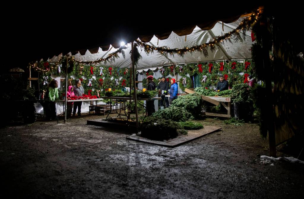 The Montano and Rodriguez families work together to assemble wreaths on Dec. 5, in Monroe. (Olivia Vanni / The Herald)