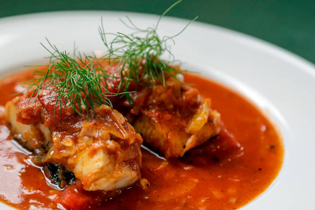 Cody Castiglia makes a dish of black cod and red sauce. Photographed in Snohomish, Washington on April 27, 2022. (Kevin Clark / The Herald)