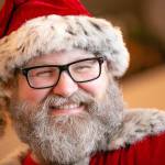 Santa Brett Nichols cracks a smile with a twinkle in his eye on Dec. 4, in Monroe. After a year of health issues, Nichols recently discovered he has oligodendroglioma, a type of slow growing brain cancer, and has begun the process of determining the best path forward. Prior to his first biopsy, he and his longtime partner Tami got married in a last-minute ceremony put together by family at Snoqualmie Pass on Nov. 20. (Ryan Berry / The Herald)