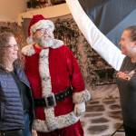 Santa Brett Nichols chats with Kristin Johnson, left, and photographer Stacy Yonkaitis, after doing a photo shoot with the Johnson family on Dec. 4, in Monroe. The three go back to their days at Sultan High School roughly 30 years ago, and have been doing yearly Christmas photos together for almost a decade. (Ryan Berry / The Herald)