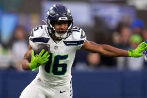Seattle Seahawks wide receiver Tyler Lockett (16) runs with the ball as Los Angeles Rams safety Nick Scott defends during the second half of an NFL football game Sunday, Dec. 4, 2022, in Inglewood, Calif. (AP Photo/Marcio Jose Sanchez)