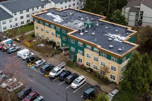 People work on the roof of the Stilly Valley Senior Center on Thursday, Dec. 8, 2022 in Arlington, Washington. (Olivia Vanni / The Herald)