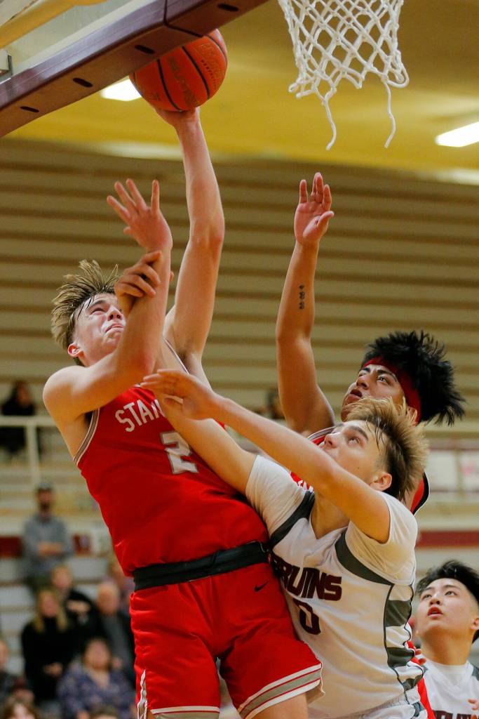 Stanwoods John Floyd tries to hit a contested layup against Cascade on Thursday, Dec. 8, 2022, at Cascade High School in Everett, Washington. (Ryan Berry / The Herald)