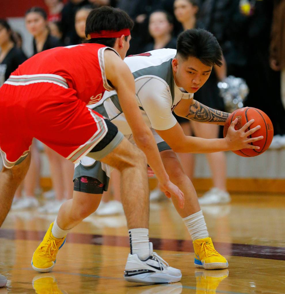 Cascades Nate Lagutang faces up a defender against Stanwood on Thursday, Dec. 8, 2022, at Cascade High School in Everett, Washington. (Ryan Berry / The Herald)