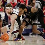 Gonzaga forward Drew Timme (left) and Washington guard PJ Fuller II battle for a loose ball during the first half of a game Friday in Spokane. (AP Photo/Young Kwak)