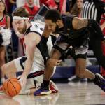 Gonzaga forward Drew Timme, left, and Washington guard PJ Fuller II go after the ball during the first half of an NCAA college basketball game, Friday, Dec. 9, 2022, in Spokane, Wash. (AP Photo/Young Kwak)