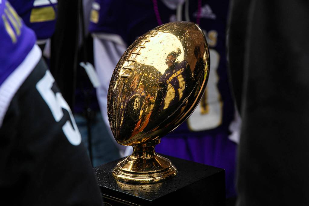 Lake Stevens football players surround their state championship trophy during their victory parade Saturday, Dec. 10, 2022, in Lake Stevens, Washington. (Ryan Berry / The Herald)