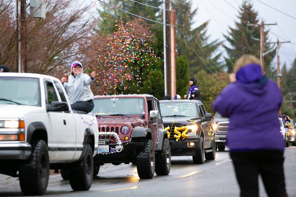 Confetti flies as a procession of cars arrives at Lake Stevens High School during the schools 4A football championship parade Saturday, Dec. 10, 2022, in Lake Stevens, Washington. (Ryan Berry / The Herald)