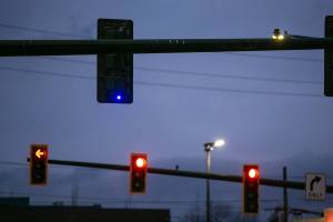A small blue light shines on the backside of a traffic signal at the intersection of Broadway and Everett Avenue on Sunday, Dec. 11, 2022, in downtown Everett, Washington. The lights are designed to help law enforcement catch drivers who blow red lights. (Ryan Berry / The Herald)