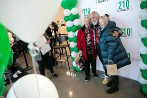 Carla Fisher and Lana Lasley take a photo together with Tommy Chong during 210 Cannabis Cos grand opening Saturday, Dec. 10, 2022, in Arlington, Washington. Fisher and Lasley waited in line solely to get a photo with Chong. (Ryan Berry / The Herald)