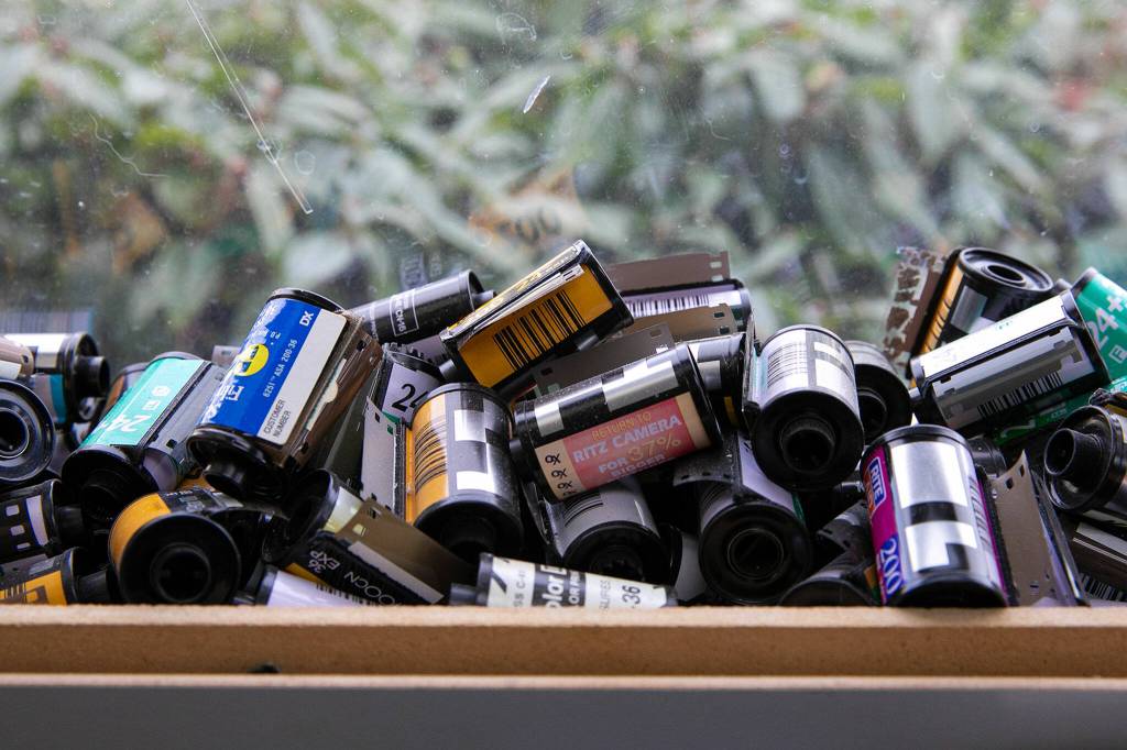 Spent film canisters from over the years line the windowsills at Kens Camera on Thursday, Dec. 15, 2022, in Everett, Washington. (Ryan Berry / The Herald)