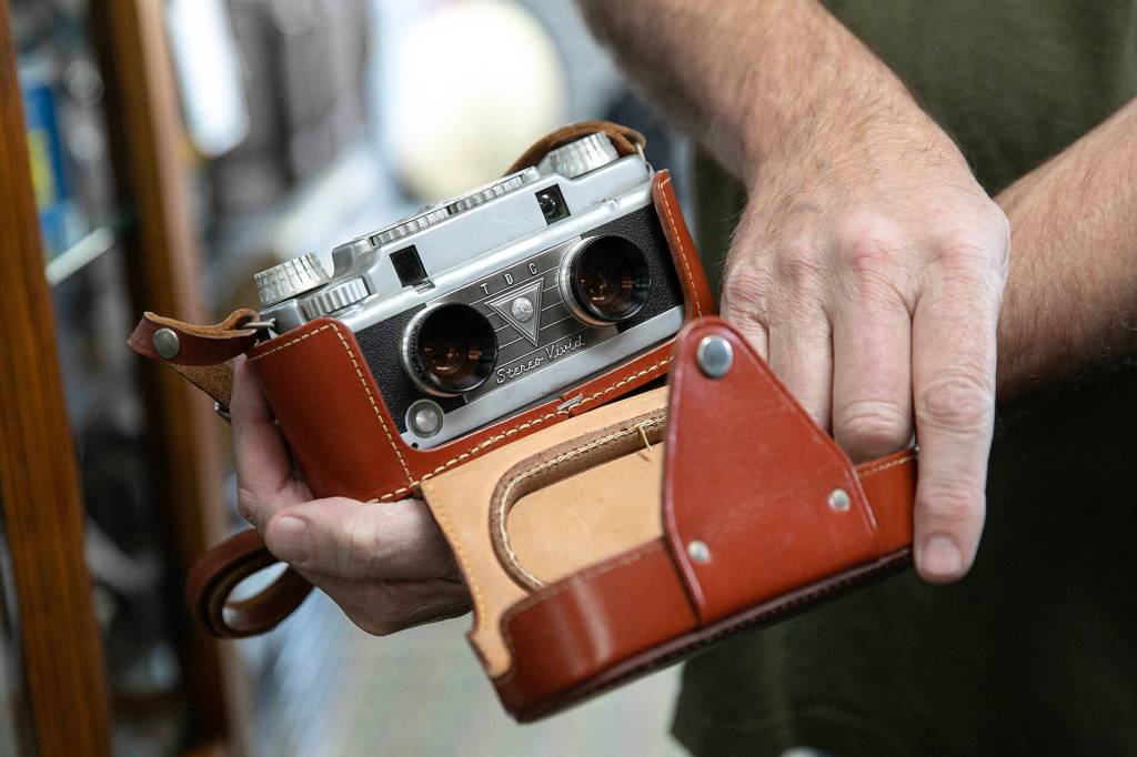 Eric Minnig shows customer Mark Harazim a Three Dimension Company Stereo Vivid rangefinder before Harazim bought it at Kens Camera on Thursday, Dec. 15, 2022, in Everett, Washington. (Ryan Berry / The Herald)