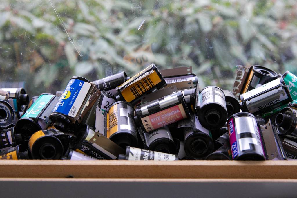 Spent film canisters from over the years line the windowsills at Kens Camera on Thursday, Dec. 15, 2022, in Everett, Washington. (Ryan Berry / The Herald)
