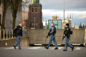 Three State Troopers get together while helping civilians get their cars out of the parking garage during a lockdown at the Snohomish County Superior Courthouse Monday, Dec. 12, 2022, in downtown Everett, Washington. (Ryan Berry / The Herald)