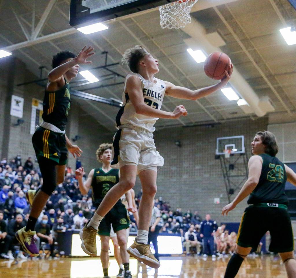 Arlingtons Leyton Martin attempts a reverse layup against Evergreen on Feb. 22 at Arlington High School in Arlington. (Kevin Clark / The Herald)
