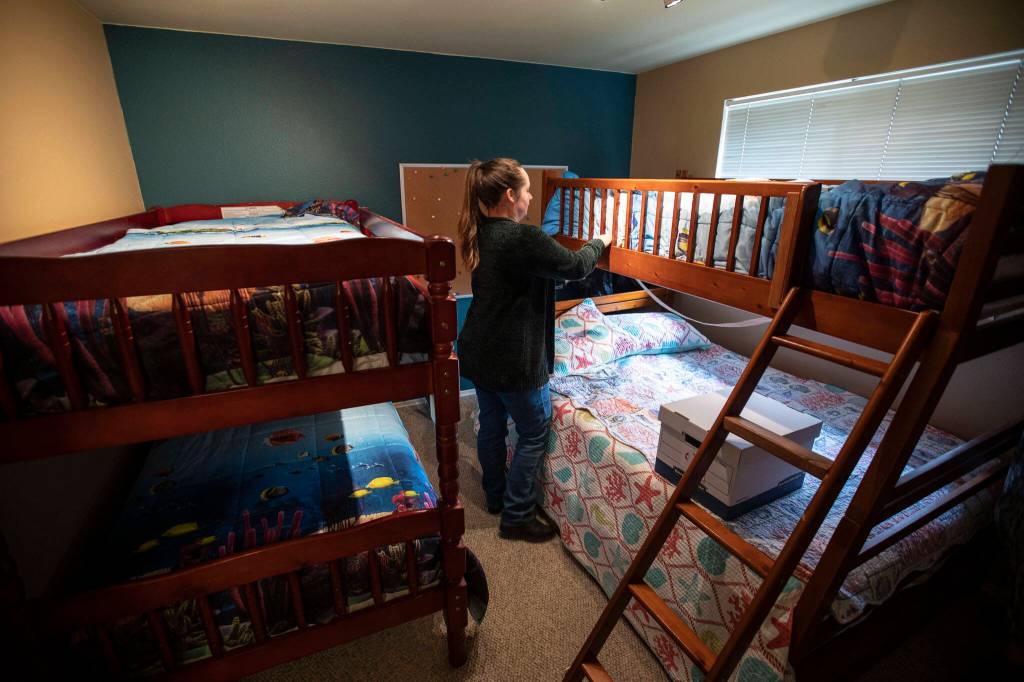 Zoë Nina finishes making a bed in the new Interfaith Family Shelter on Thursday, in Everett. (Olivia Vanni / The Herald)