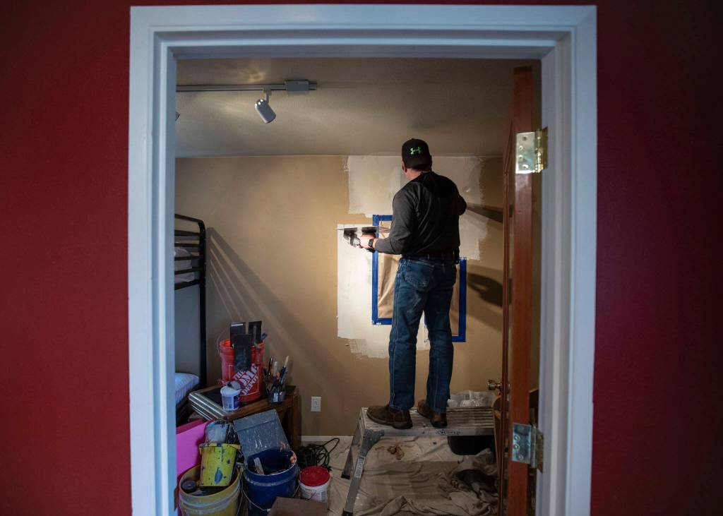 Kevin Soda places putty on a wall in the new Interfaith Family Shelter on Thursday, in Everett. (Olivia Vanni / The Herald)