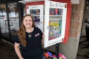 Paddywack co-owner Shane Somerville with the 24-hour pet food pantry built by a local Girl Scout troop outside of her store on Tuesday, Dec. 20, 2022 in Mill Creek, Washington. (Olivia Vanni / The Herald)