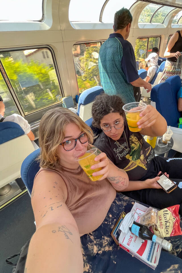 Writer Julia Carmel (left) gets comfortable with partner Reanna on the very crowded (and slightly stinky) observation car. (Julia Carmel / Los Angeles Times)