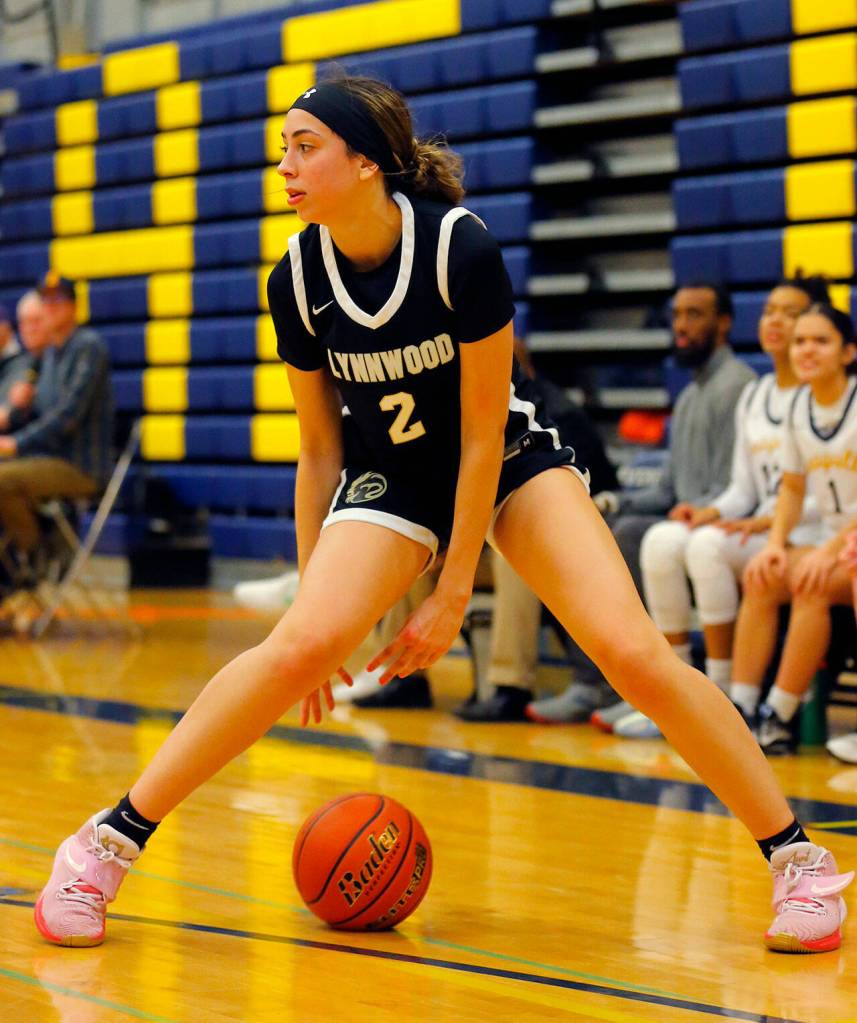 Lynnwoods Kayla Lorenz goes between the legs while looking for someone to pass to against Everett on Thursday, Dec. 15, 2022, at Norm Lowery Gymnasium in Everett, Washington. (Ryan Berry / The Herald)