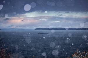 Snow begins to fall over Possession Sound as the sun sets on Sunday, Dec. 18, 2022 in Everett, Washington. (Olivia Vanni / The Herald)