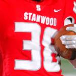A Stanwood football player signals for a first down after holding onto a pass through hard contact against Lakes High School on Nov. 4, at Stanwood High School in Stanwood. (Ryan Berry / The Herald)