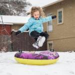 Halle Lucas-Roberts, 6, leaps onto her tube while sledding in front of her home on Tuesday, in Everett. (Olivia Vanni / The Herald)