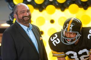 FILE - Former Pittsburgh Steelers running back Franco Harris stands next a statute of himself on Sept. 12, 2019, at Pittsburgh International Airport near Pittsburgh. Harris died on Wednesday morning, Dec. 21, 2022, at age 72, just two days before the 50th anniversary of The Immaculate Reception. (Nate Guidry/Pittsburgh Post-Gazette via AP, File)