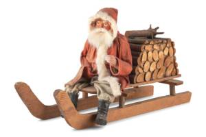Leave it to Santa Claus to fill a bundle of firewood with candy! This papier-mache figure of Santa on a sled is a candy container.