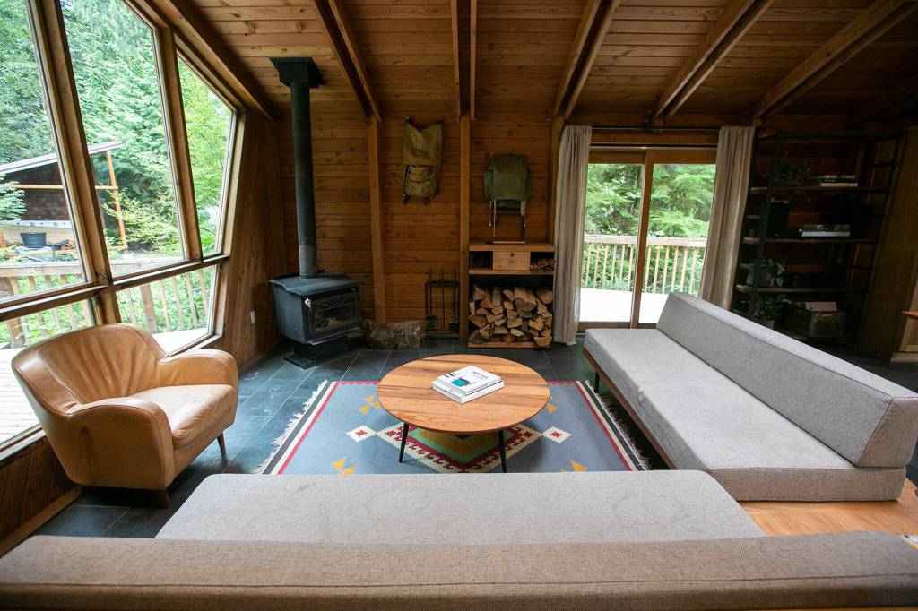 The living space in Cabin 1 is furnished with seating built by co-owner Andy Whitcomb at Canyon Creek Cabins on Sep. 23, in Granite Falls. (Ryan Berry / The Herald)
