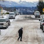 A pedestrian navigates compact snow and ice while crossing the street on Thursday, Dec. 22, 2022 in Everett, Washington. (Olivia Vanni / The Herald)