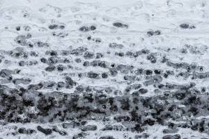 Ice freezes over footprints along Rockefeller Avenue on Thursday, Dec. 22, 2022 in Everett, Washington. (Olivia Vanni / The Herald)