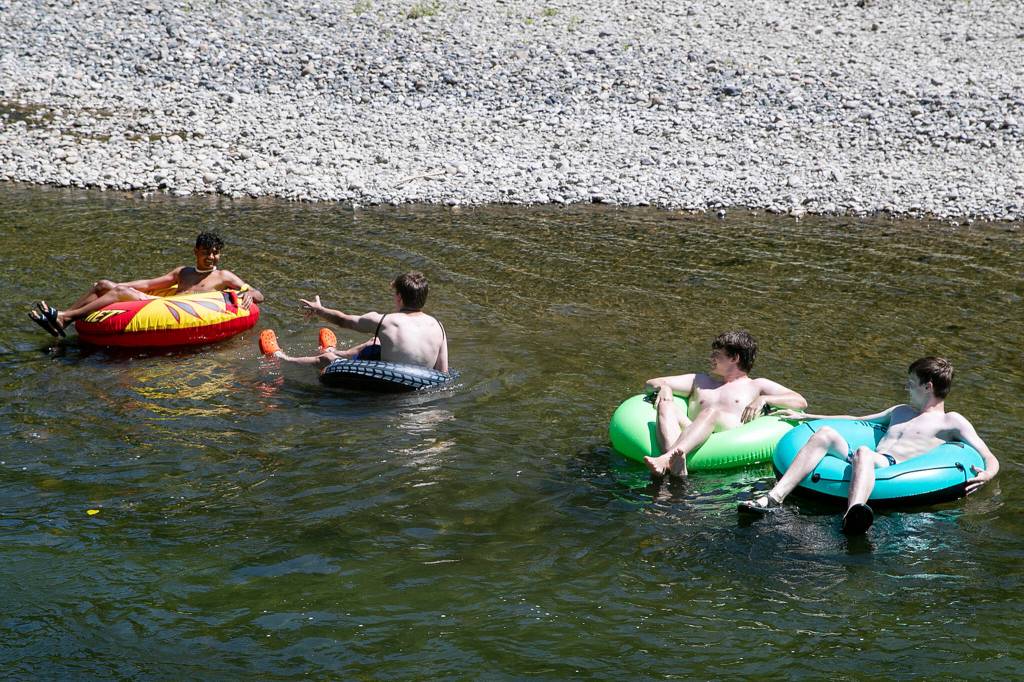 Teenagers tube the waters of the Pilchuck River Wednesday afternoon in Snohomish, Washington on July 20, 2022. (Kevin Clark / The Herald)