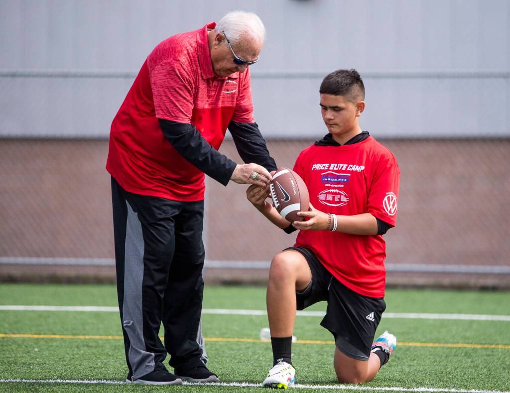 Former college football coaching legend Mike Price works with a player on his throwing technique during his Price Elite Camp on June 8, 2022 in Everett. (Olivia Vanni / The Herald)