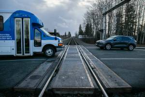 Vehicles heading both directions cross the train tracks on Grove Street between State and Cedar on Friday, Dec. 30, 2022, in Marysville, Washington. $3 million in federal funding will help the city build an overpass above the tracks to ease the frequent backups caused by trains passing through the area. (Ryan Berry / The Herald)